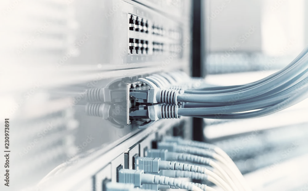 Ethernet cables plugged into ports on a network server rack